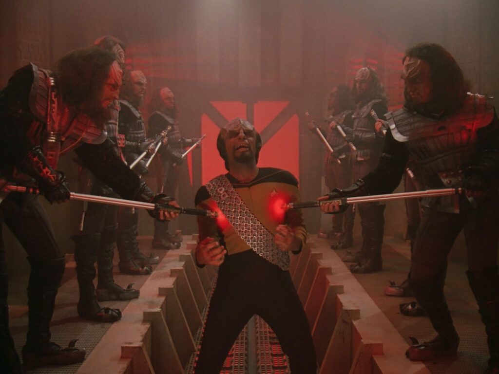 Star Trek Klingon Worf being tormented with pain sticks