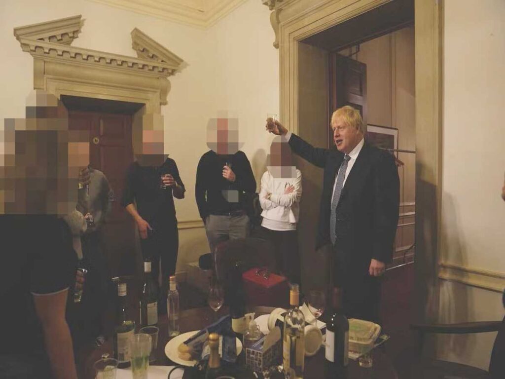 Photograph taken at a party held in Number 10 Downing Street during the pandemic lockdown. Prime Minister Boris Johnson holds up a glass in a toast.
